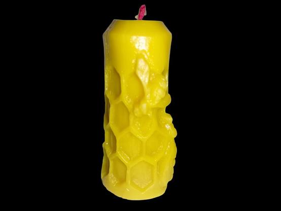 Une bougie avec des abeilles sur des alvéoles.