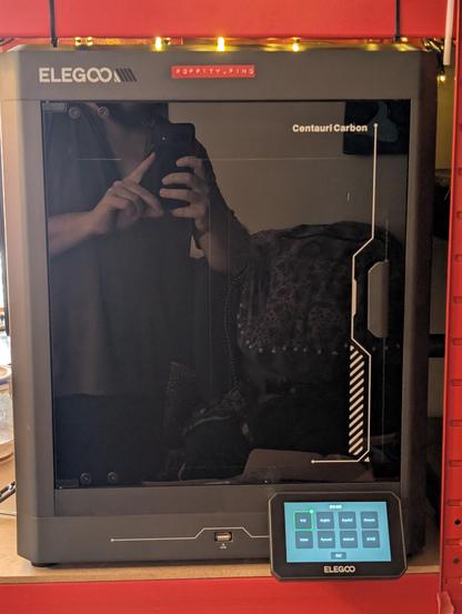 Photo of a 3D printer on a shelving unit