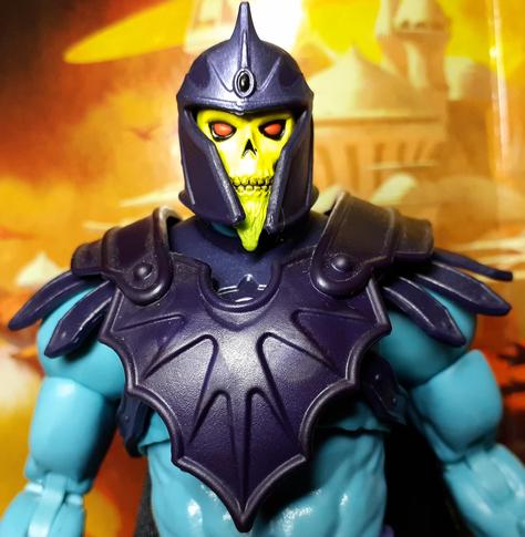 A photo of the head and shoulders of the action figure Barbarian Skeletor. Skeletor has the usual light blue skin and purple armour but this version also has a chin beard and a helmet.