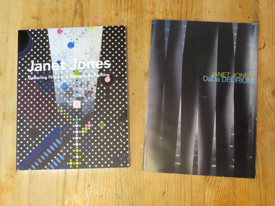 Two books resting on a table featuring a black and white patterned surface.