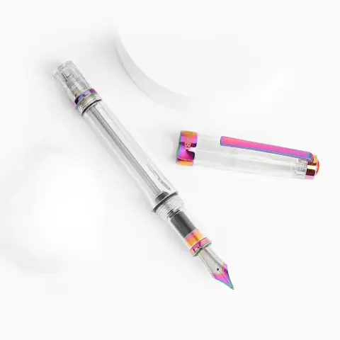 Product image of the TWSBI VAC700R IRIS showing the clear demonstrator pen and unposted cap with metal components finished in a "rainbow" style.