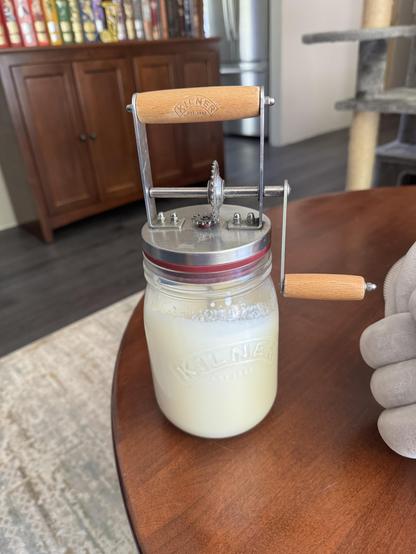 A small hand cranked butter churn full of cream. Not yet butter. Still a ways to go until it's solid. So much churning left to do. It never ends.