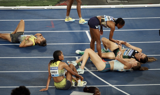 Chebet feeling very sprightly after easily winning her race shakes the hands of her wiped out competitors 