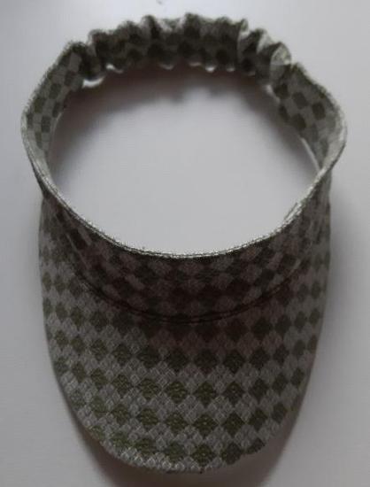 Sun Visor in a white/green diamond patterned fabric on a table. 