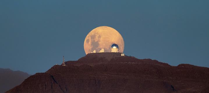 Another night of observing begins at the U.S. National Science Foundation Cerro Tololo International Observatory (CTIO) in the Chilean Andes, a Program of NSF NOIRLab, as the Moon sets below the horizon. The Moon appears massive and with a mysterious yellowish glow as it retreats behind the SMARTS–GSU 0.9-meter Telescope on the left, the SMARTS–GSU 1.5-meter Telescope in the center, and the Víctor M. Blanco 4-meter Telescope on the right. Both the SMARTS-GSU telescopes are operated by the Georgia State University Research Foundation. 