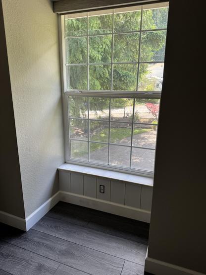 A large bedroom window with vertical boards below the sill, approximately 12" to the baseboard. 
