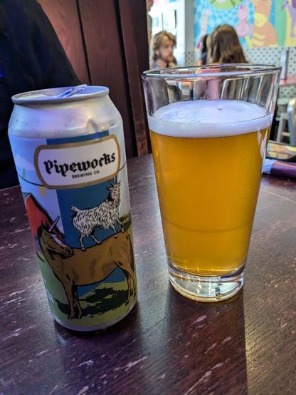A can of Pipeworks Maibock bier sits next to a pint glass full of beer.