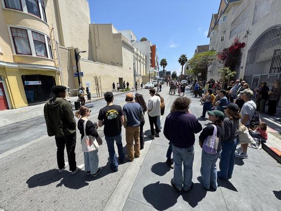 A large crowd standing in Bartlett watching a folk musician perform. 