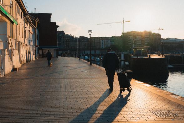 Eine Person mit Wägelchen am Hafen