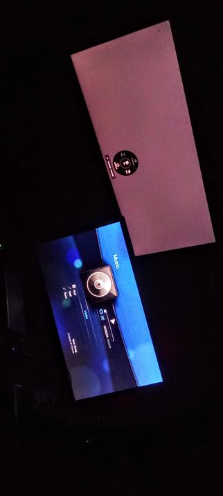  The photograph shows two IPS LED panels in a pitch dark environment. The top screen is a large, angled display with a pinkish-purple hue, featuring a circular control sticker with buttons labeled "I," "G," "U," and "D." The bottom screen is a smaller, rectangular display with a blue interface, showing a music player interface with a circular icon resembling a vinyl record. The interface includes text such as "Rock," "Sound," "Violet," and "Next Song," along with a track number "0000341" and a timestamp "00:00:30." The screens are positioned diagonally, with the bottom screen slightly tilted towards the viewer.

 Ovis2-8B

🌱 Energy used: 0.190 Wh