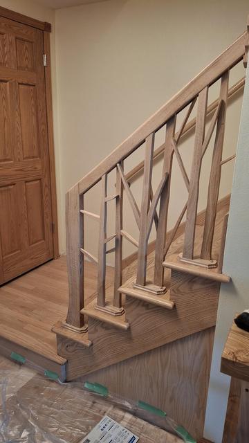 The banister I made from oak off our land. Started rough milled. The shapes of the balusters are tree-like. The oak is not stained and covered in satin poly.