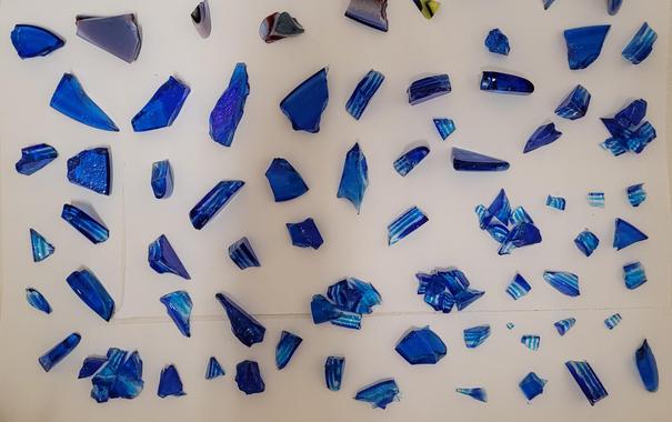 An assortment of smashed up glass that will be fired into cabochons.  There are varying sizes, but they're all from the same stack of puddled glass, and are different shades of blue with clear glass in between.