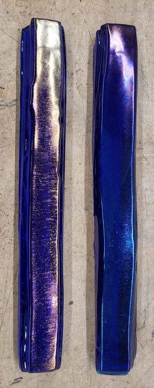 Two fused glass pattern bars shot from above.  They're layers of blues and clear glass. They look like big glass sticks.