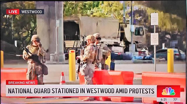 Image description/alt text: Screencap of NBC live feed dateline Westwood shows three people wearin camo with rifles or longarms of some sort either in their hands or slung over them. They're standing near tall yellow bollards on a corner and across the street appears to be a matching desert camo-colored truck with fabric covered canopy truck bed.

Chyron says "Breaking News"National Guard Stationed in Westwood Amid Protests" and time is 6:21. Temp 77F.  #AltText4You #LosAngeles