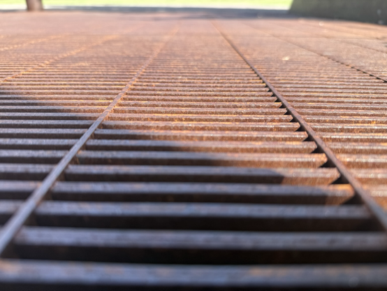 Leading lines on a rusted sidewalk grate. 