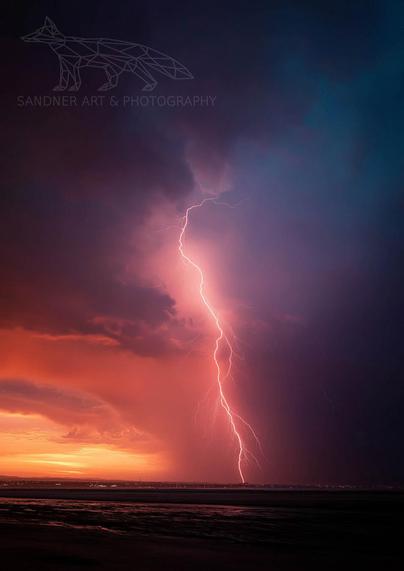 A powerful bolt of lightning strikes down from a dramatic, multi-coloured sky of orange, purple, and dark blue. The storm is taking place over a body of water at sunset, with the horizon glowing warmly.