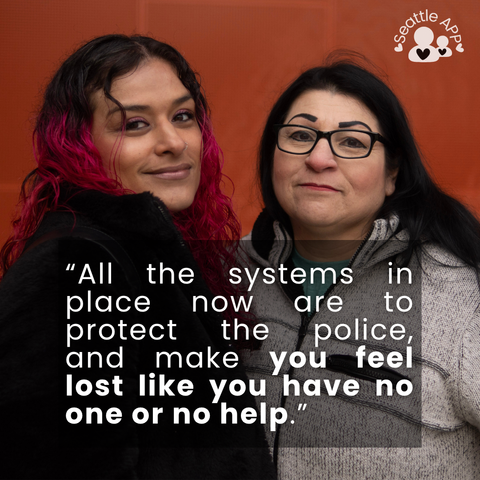 Image description: Image is of two women hugging and smiling while looking directly into the camara. In the corner of the image is the Seattle APP logo.

On top of the photo is a transparent black box with white lettering. The text in the middle of the box is the following “All the systems in place now are to protect the police, and make you feel lost like you have no one or no help.”
