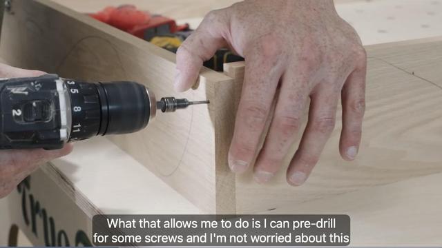 Door jamb assembly pre-drilling pilot holes for screws. Video screenshot with the caption "What that allows me to do is I can pre-drill for some screws and I'm not worried about this" 