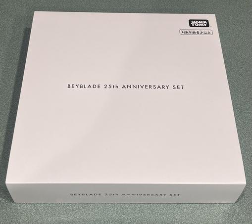 An image of a white box with the Tamara TOMY logo in the corner and centered text reading “BEYBLADE 25th ANNIVERSARY SET”.