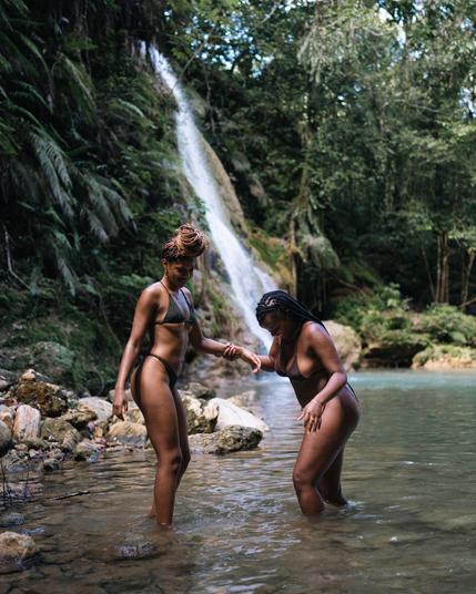 Two women having a relaxing day at a waterfall escape in the jungle.