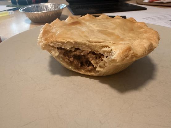 Beef and onion pie with a bite taken out of it. 
