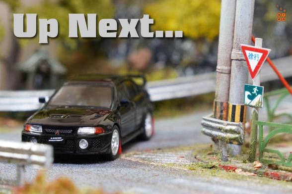 A Mitsubishi Lancer GSR Evolution V 1998 with Mud Flap, Pyrenees Black by Hobby Japan in 1:64 scale on AREA 164