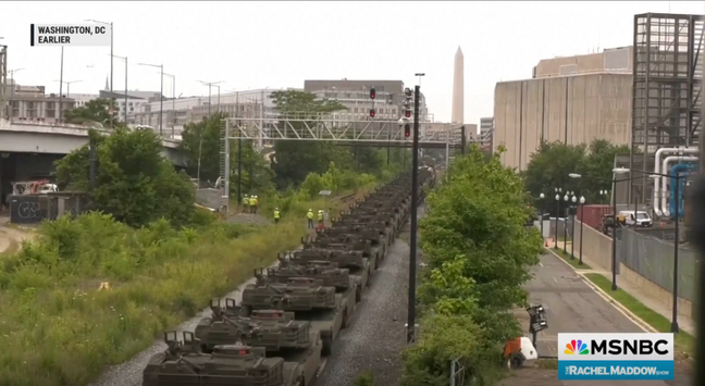 Snapshot from a video that last several seconds (at least) of a freight train hauling about a half mile of closely packed U.S. Army tanks.