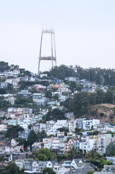 A telephoto image of houses on a hill. The zoom lens compresses the layout and makes it look almost as if the houses are clinging to a wall