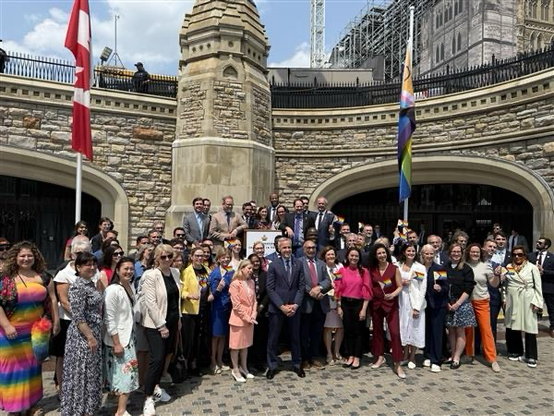 Parliamentarians raise Pride flag on Parliament Hill. 
