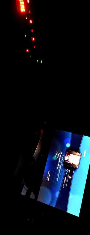 The photograph composed in absolute pitch black darkness shows a dimly lit environment with a television screen displaying a menu interface. The screen is tilted and angled, making it difficult to read the text clearly. The top part of the image is dominated by a dark background with a red neon sign that reads "STAR" in capital letters, with additional red lights arranged vertically. The bottom part of the image features a blue screen with a menu, including options like "Music" and "In a Van Full of Stars (feat. Legend Avenue)." The screen also shows a small thumbnail image of a person, likely a performer, with a play button and a progress bar indicating the song's duration. The overall lighting is low, with the screen being the primary source of illumination.

 Ovis2-8B

🌱 Energy used: 0.688 Wh