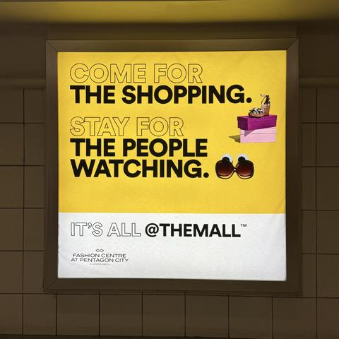 A display ad at the same mall that says “come for the shopping, stay for the people watching”