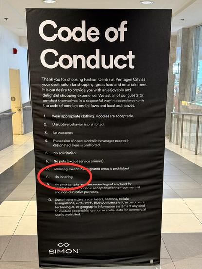 A code of conduct sign at the mall that includes many rules, including one circled in red that says “no loitering”