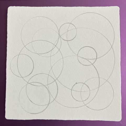 A series of interlocking circles of different sizes, drawn in pencil on the tile. 