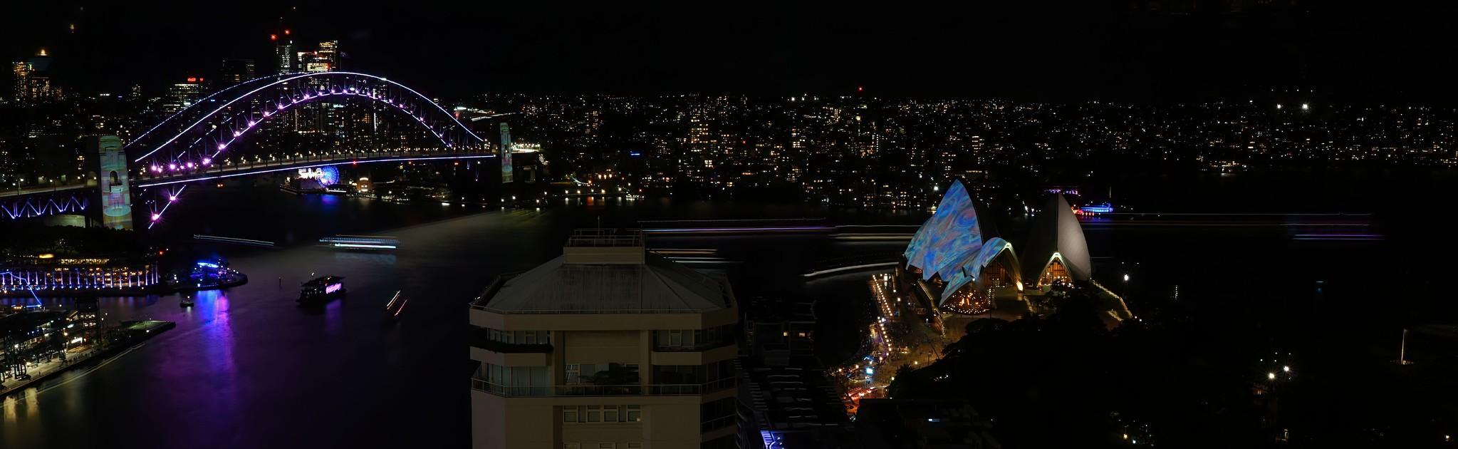 On a crisp evening during Vivid Sydney, the harbor comes alive with a mesmerizing symphony of light, color, and movement. The Sydney Opera House glows with animated projections, its sails transformed into a shifting canvas of art, while the Harbour Bridge pulses with rhythmic beams that dance across the water. Reflections ripple in the bay, amplifying the brilliance of neon blues, radiant purples, and golden hues that seem to melt into the night. Boats glide through the glowing waves, trailing streaks of light like brushstrokes on a dark canvas. The entire bay feels electric—buzzing with energy, music, and awe, as people gather along the shoreline to witness the city’s most dazzling celebration of creativity. On a crisp evening during Vivid Sydney, the harbor comes alive with a mesmerizing symphony of light, color, and movement. The Sydney Opera House glows with animated projections, its sails transformed into a shifting canvas of art, while the Harbour Bridge pulses with rhythmic beams that dance across the water. Reflections ripple in the bay, amplifying the brilliance of neon blues, radiant purples, and golden hues that seem to melt into the night. Boats glide through the glowing waves, trailing streaks of light like brushstrokes on a dark canvas. The entire bay feels electric—buzzing with energy, music, and awe, as people gather along the shoreline to witness the city’s most dazzling celebration of creativity.