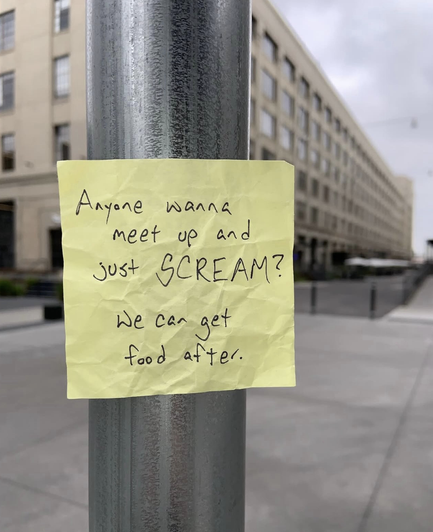 Note on a post in the city, reads "anybody wanna meet up and SCREAM? We can get food after." 