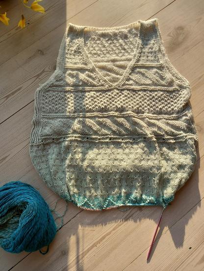 Haut de robe en cours de tricot avec des motifs géométrique en relief grace au point envers