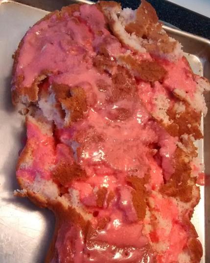 A disaster of a crumbly cake that is barely being held together with a bunch of icing that in an alarming shade of pink.

