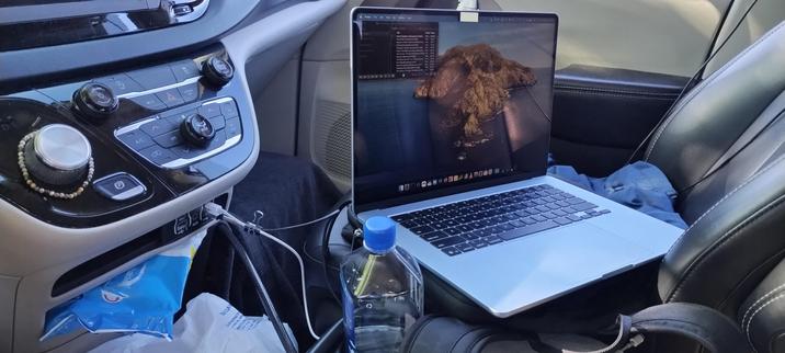 Photo of front seat of van with laptop open and VLC playlist showing Abbey Road playing