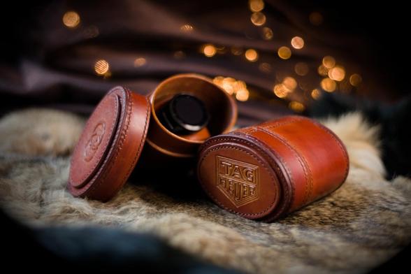 Brown oval shaped leather boxes set onto hair on skin. One of the boxes is opened, the lid set aside and there is a watch in it. These boxes were crafted to transport watches safely.  