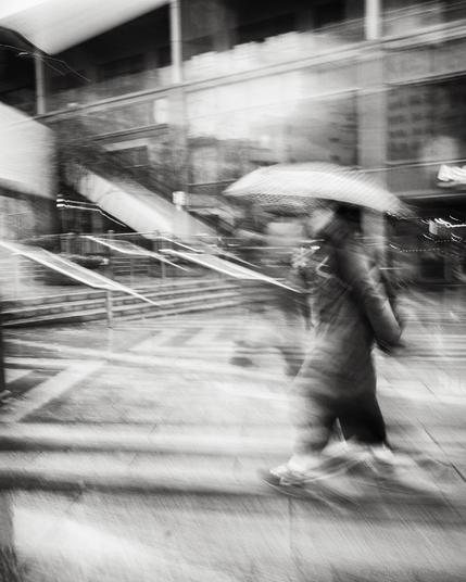 Black and white photo of person holding an umbrella.