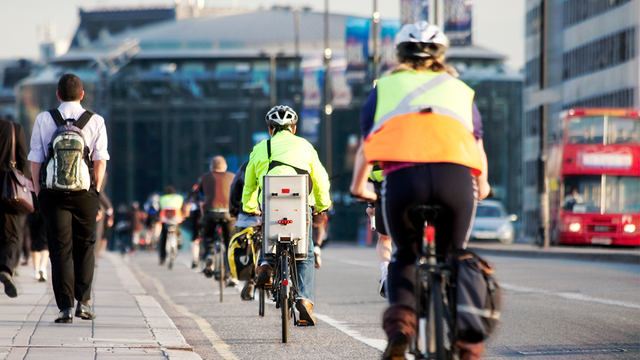 Viele Menschen fahren mit dem Fahrrad auf einer Straße in London.
