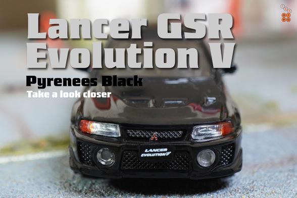 A close-up shot of Mitsubishi Lancer GSR Evolution V 1998 with Mud Flap, Pyrenees Black by Hobby Japan in 1:64 scale on AREA 164
