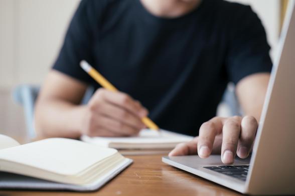 Een man die op een laptop zit te werken.