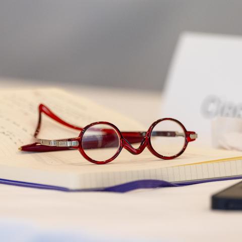 Closeup still life of red eyeglasses on a notebook.
