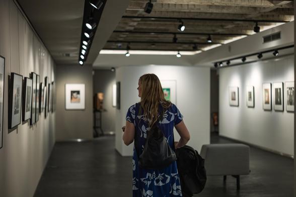 My wife pushing a stroller with our child in a photo gallery.