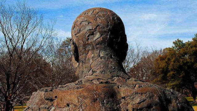 Back of statue of bald person.