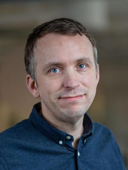 A photo of Gabriel looking happy, wearing a dark blue shirt.