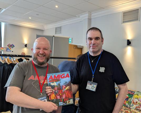 A picture of Ian Griffiths, editor of Amiga Addict, and Andy Davidson, creator of Worms, holding the Worms issue of the magazine.