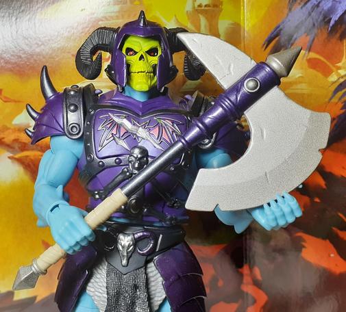 In this photo of Battle Armor Skeletor, Skeletor is holding a large battle axe with the handle in one hand and the blade of the axe in the other. The pose is supposed to look as though Skeletor is menacingly stroking the blade.