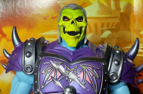 A final photo of Battle Armor Skeletor. Here, we have a close up of the head and shoulders of Skeletor. The horned helmet has been removed to show that Skeletor is wearing a sort of chain mail coif. Basically plastic in a light grey moulded to look like chain mail. The jaw of Skeletor's face/skull can be opened to make it look like he is enjoying an evil laugh.
